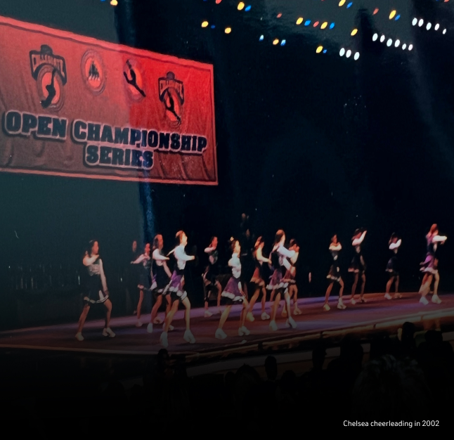 A group of female cheerleaders performing on stage at a cheerleading competition