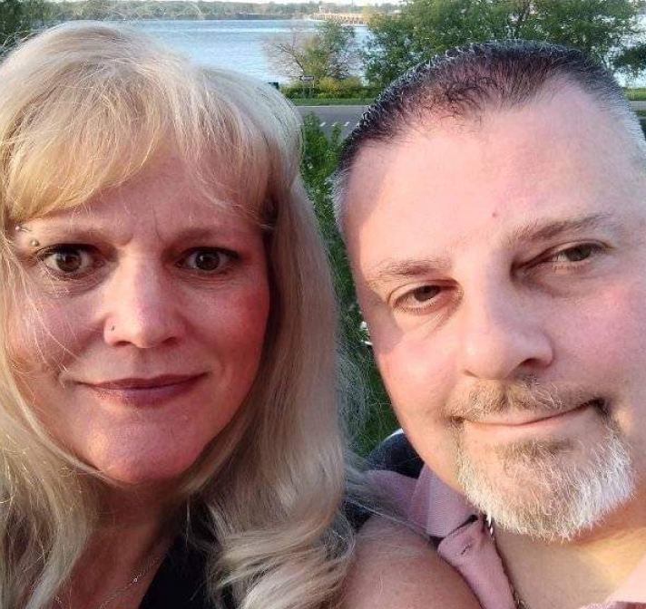 PAH patient, Rochelle, and her male caregiver, Tim, smiling outdoors at the lake