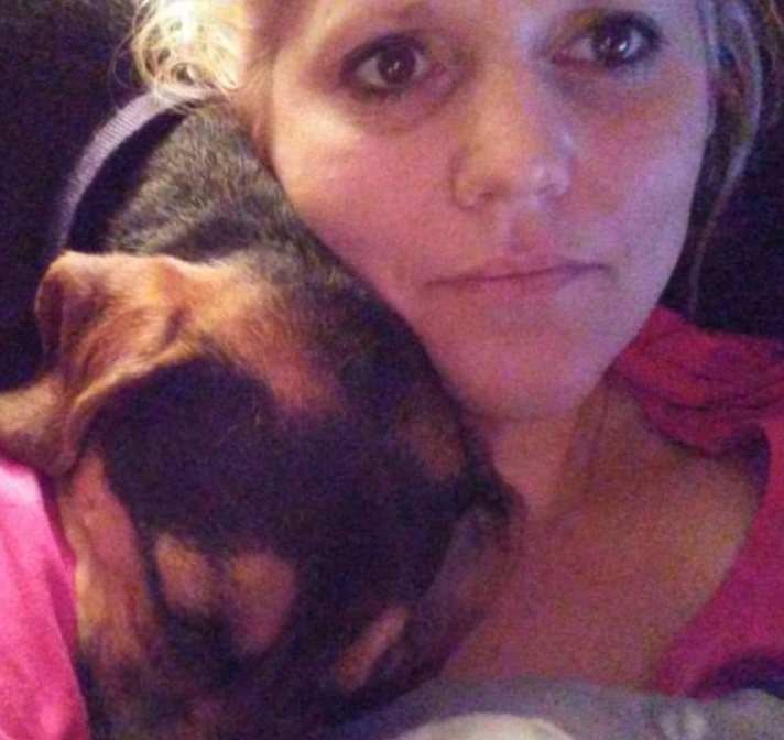 PAH patient, Rochelle, wearing a pink shirt and taking a selfie with her sleeping dog