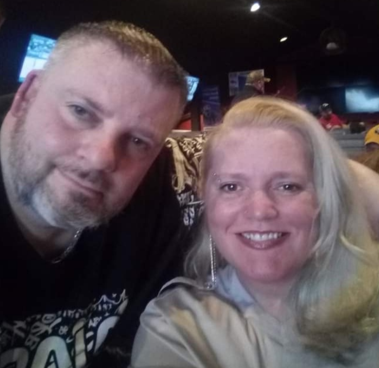 PAH patient, Rochelle, and her male caregiver, Tim, sitting and smiling inside a restaurant