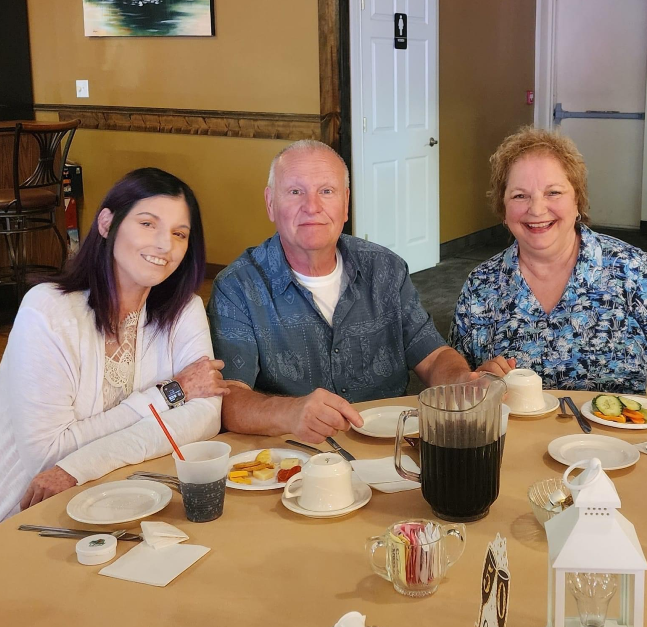 Scleroderma and PAH patient, Amy, smiles while sitting with her parents at a restaurant