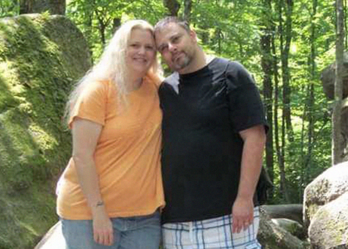 PAH patient, Rochelle, and her male caregiver, Tim, standing in front of green trees