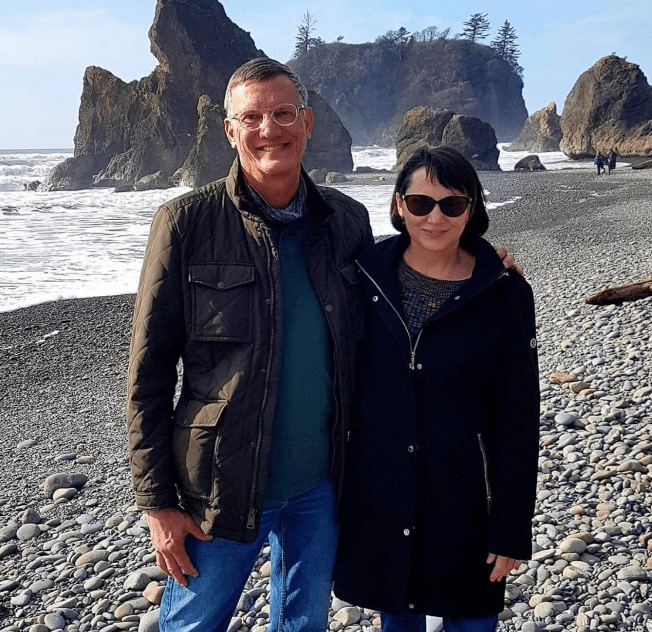PAH patient, Steve, and his wife smiling together at a rocky beach